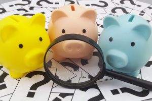 Three piggy banks with a magnifying glass looking at the Ultimate Bankruptcy Guide