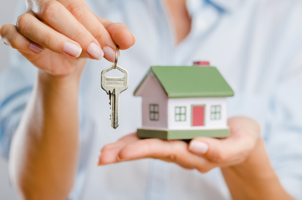 Person holding key in one hand and miniature house in the other. Wondering what will happen to your house if you're looking at Manchester bankruptcy advice? Bankruptcy Guide has the answer.