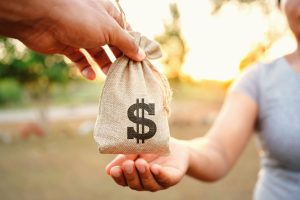 Handing over a bag of money showcasing give away property before going bankrupt.