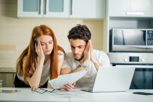 Young couple worried about debt showcasing joint debts and bankruptcy