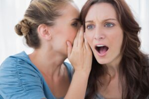 Woman being told a secret by her friend showcasing who will find out you are bankrupt