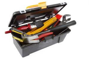 Tools in open toolbox on plain background showcasing what happens to work tools if you go bankrupt